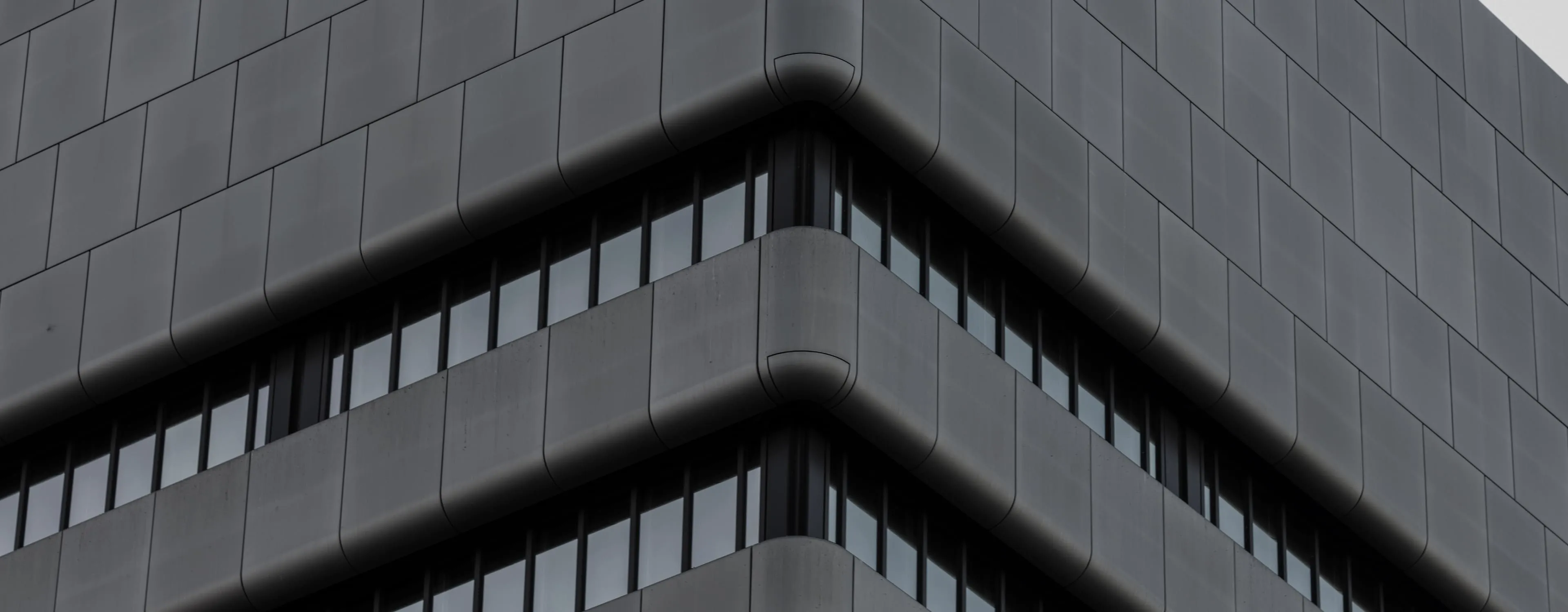 The corner of a modern block, storeys of windows receding.